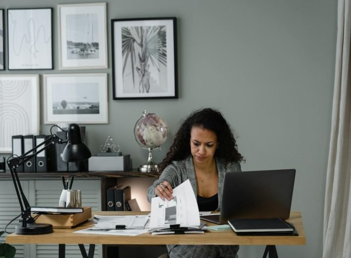 Adulte professionnel concentré examinant des documents au bureau dans un environnement de bureau moderne.